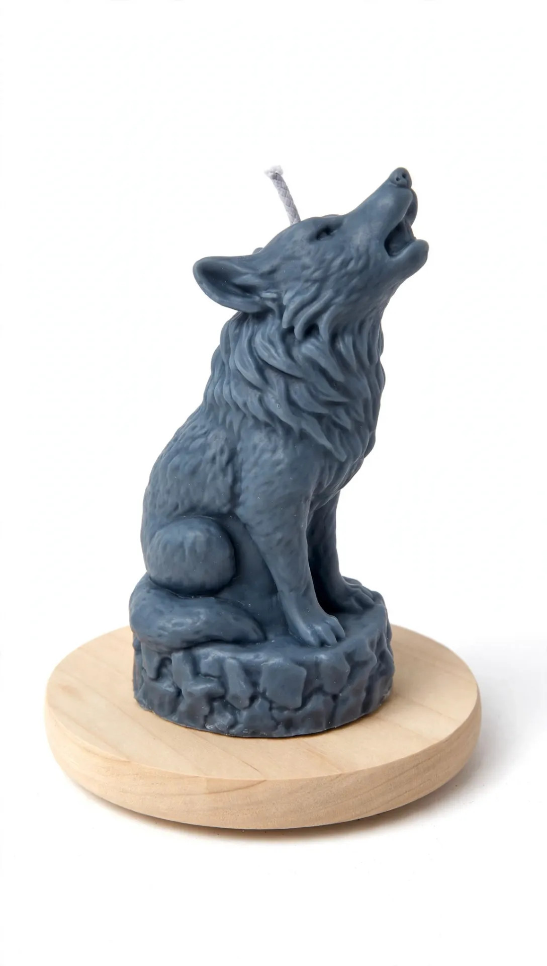 Sininen koiranpatsas istuu puualustan päällä, pää koholla ja häntä taaksepäin, valkoisella taustalla. Susi, Wolf